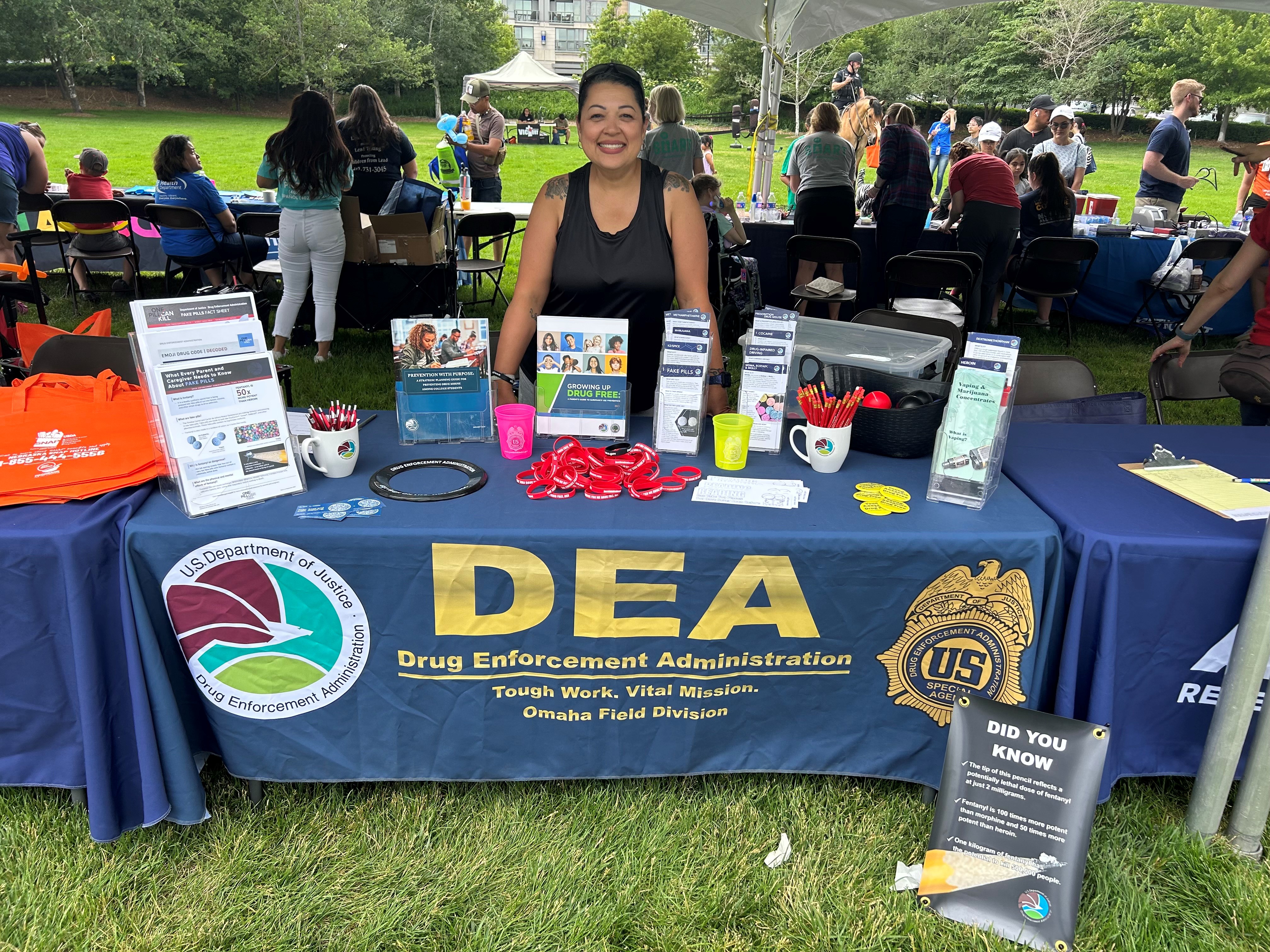 A member of DEA stands behind a table with resource information.