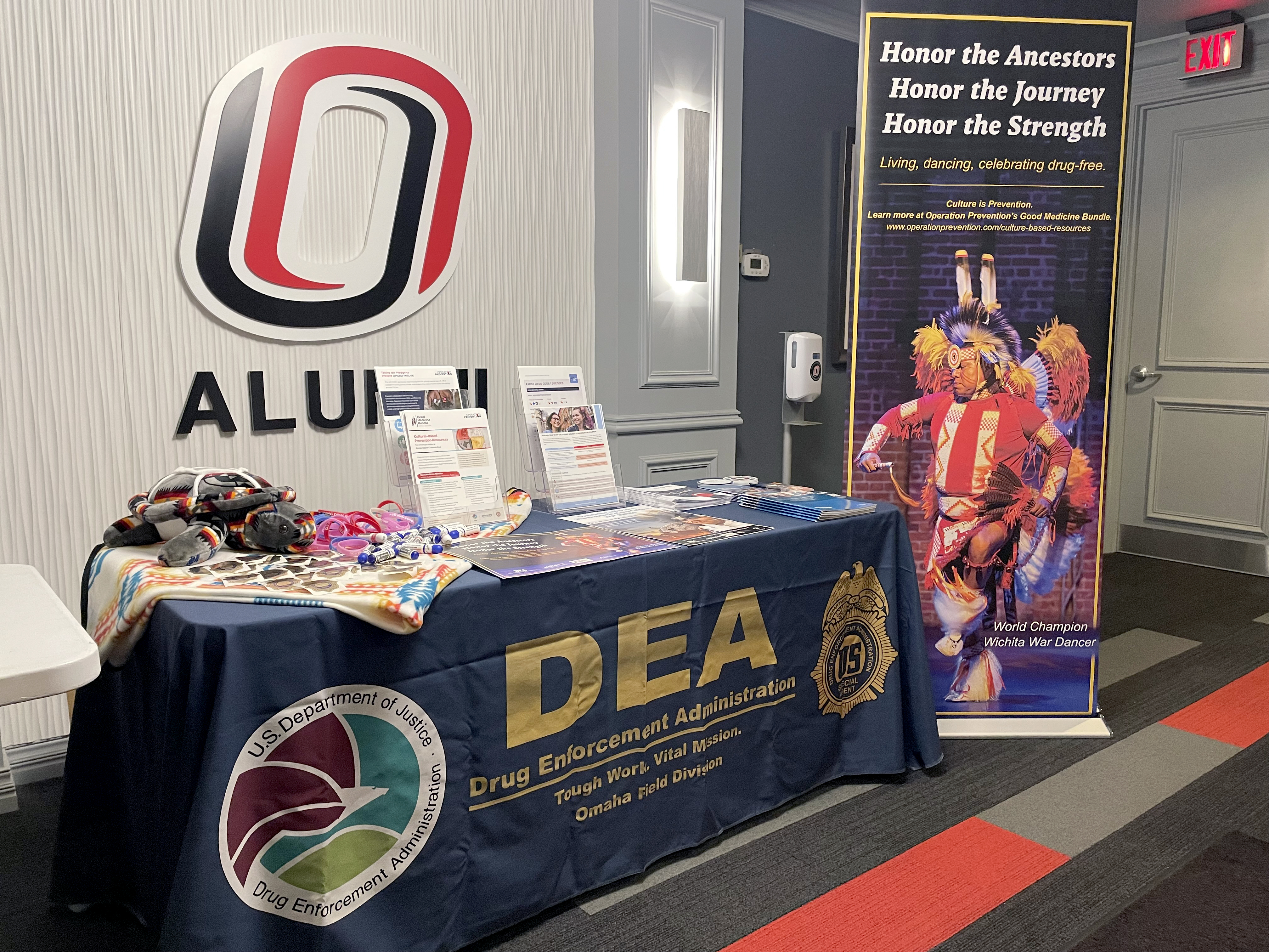 A banner featuring the Wichita War Dancer stands next to a DEA resource table.