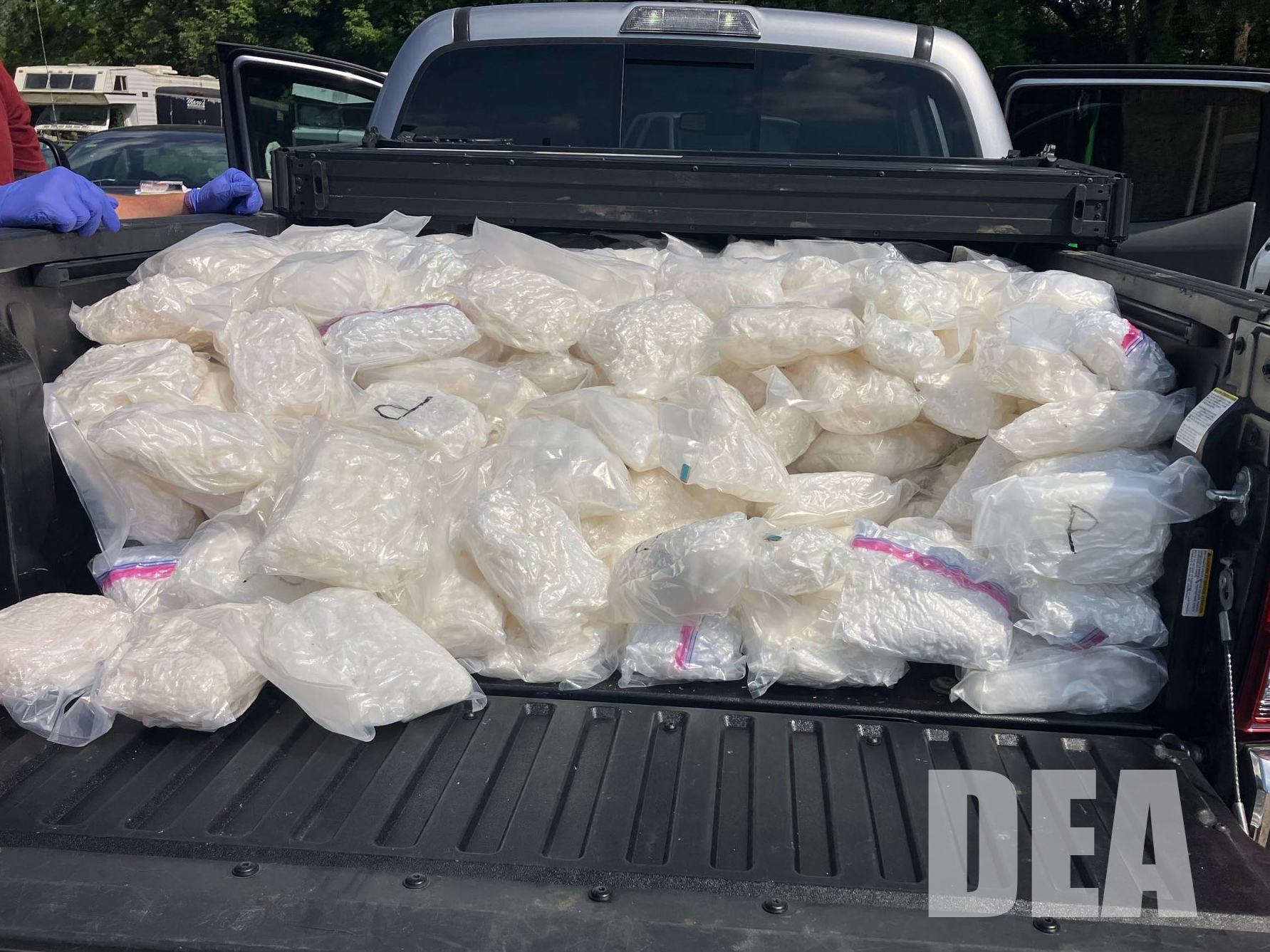 Ziplock bags full of methamphetamine cover the bed of a pickup truck.