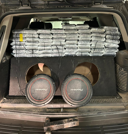 58 kilograms of cocaine packaged and stacked on top of speaker in the back of an automobile.