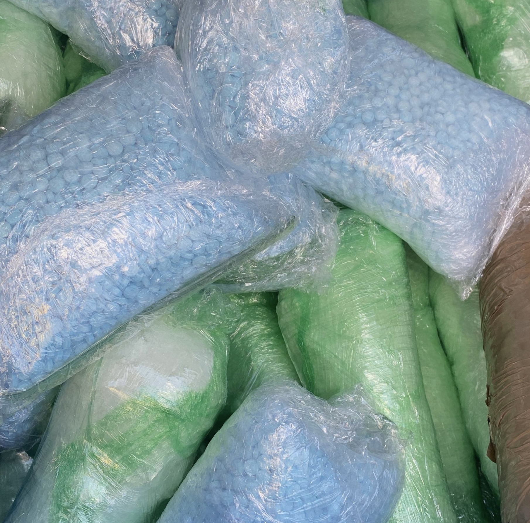 Recently seized fentanyl pills in both clear and green wrapping