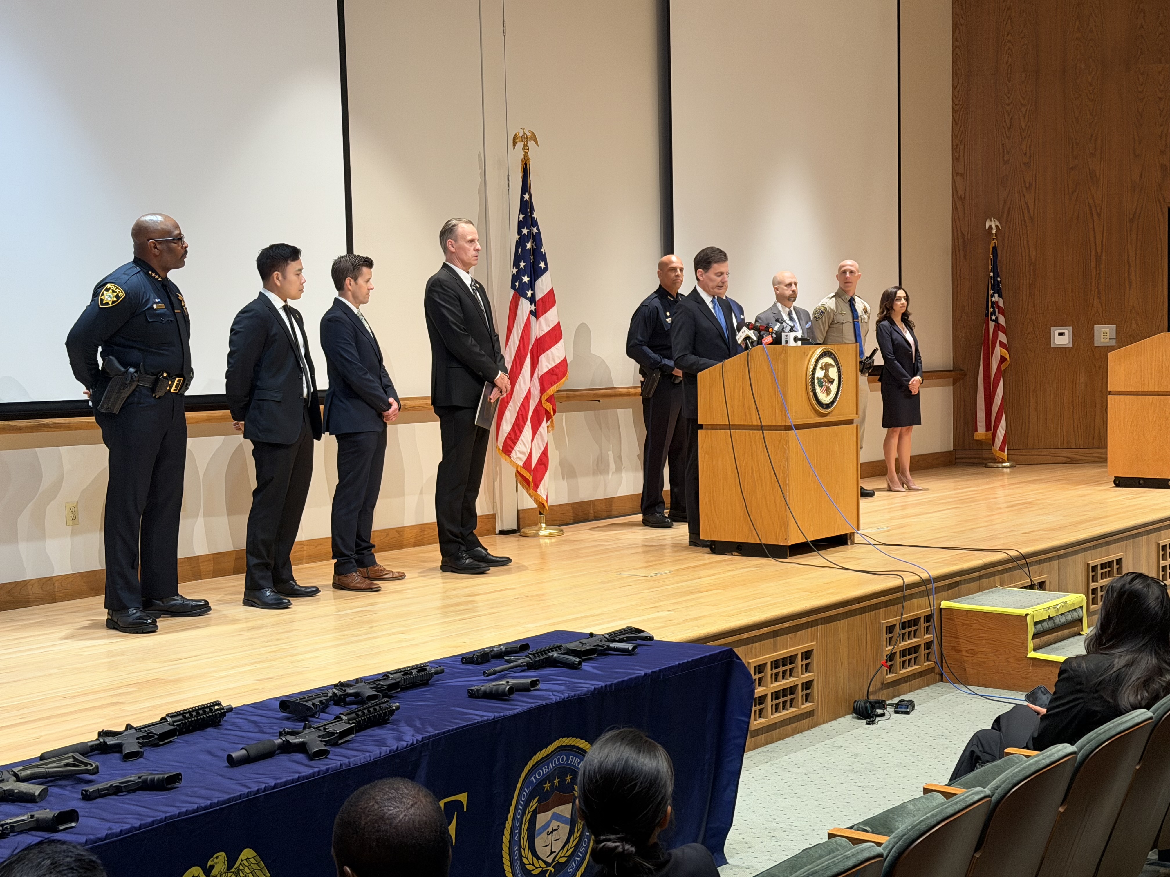 Press conference with law enforcement organizations on stacge standing shoulder to shoulder announcing successful results of a violent crime operation in Oakland.