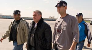 Ze'ev Rosenstein (right) is escorted by federal agents as he boards a plane bound for the United States.