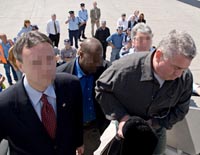 Ze'ev Rosenstein (right) is escorted by federal agents as he boards a plane bound for the United States.