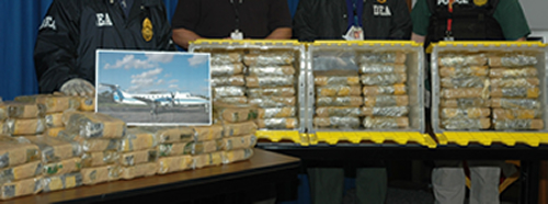 Photo shows cocaine seizure and photo of aircraft.