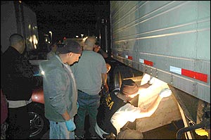 DEA Agents search underneath the tractor trailer which was hiding over 1,000 pounds of cocaine.