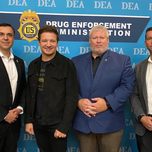 Actor Jeremy Renner standing with DEA Leadership.