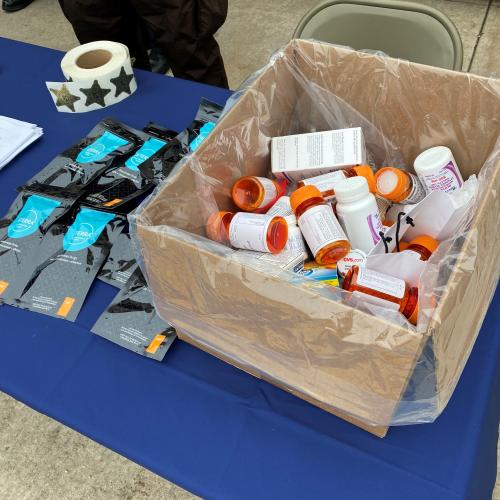 A brown box holds several orange medicine bottles.