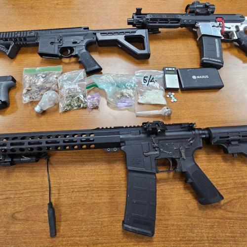 multiple firearms and evidence on a table