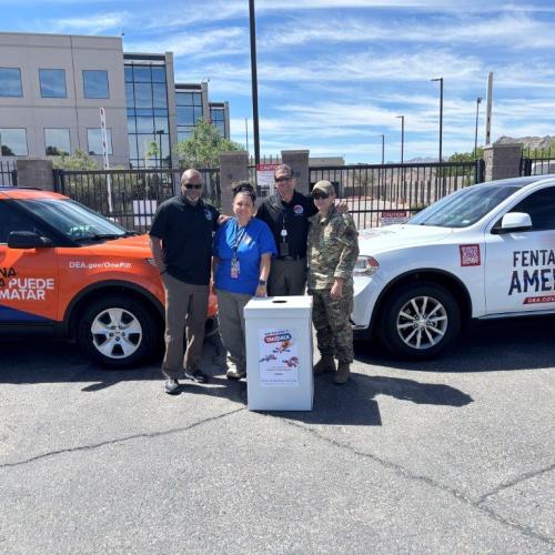 Photo of two DEA wrapped vehicles. In front of the vehicle are three DEA employees and one Texas National Guardsmen standing in front of a DEA Take Back box.