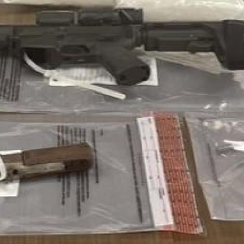 A brown table displaying 5 firearms.