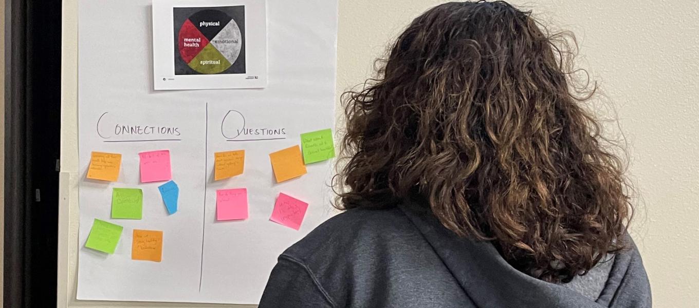 woman looking at notes posted on a wall