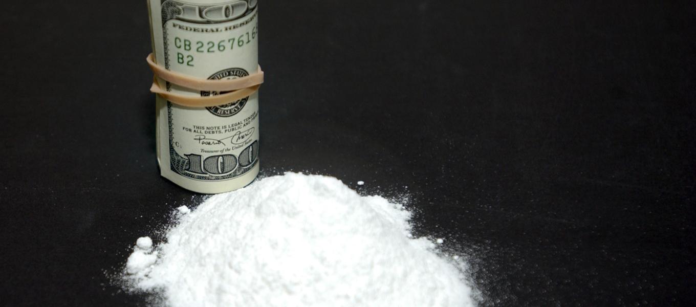 Powder cocaine next to a roll of cash.