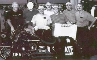 From left to right (front row): Blake Andis, Washington County Sheriff's Office (WCSO), and SA Michael Cash (DEA). From left to right (back row): Bruce Lamber, ATF RAC, unidentified agent, Sheriff Fred Newman (WCSO), Detective Chris Hazelwood (WCSO), and Captain Jack Davidson (WCSO).