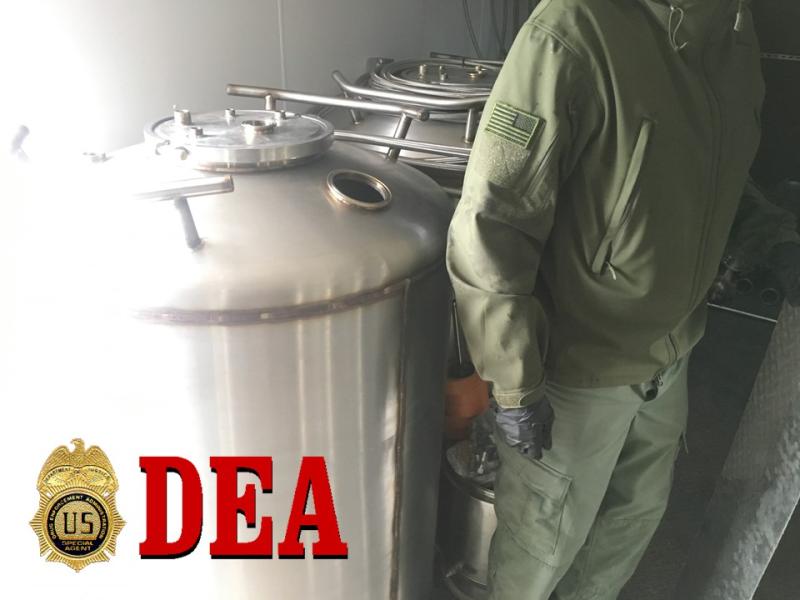 Large butane canisters next to officer for size comparison