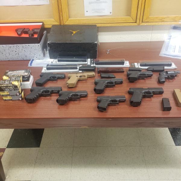 Photograph of handguns arrayed on a table that were seized from a trafficker.
