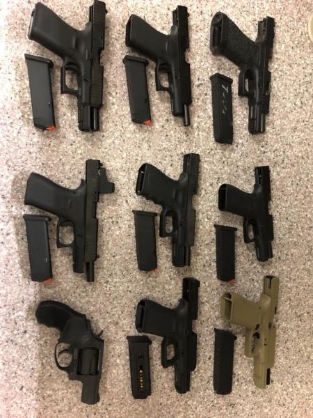 Photograph of handguns arranged on a table that were seized from one gun trafficker.