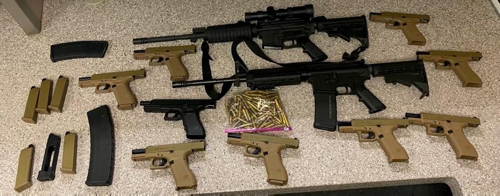 Photograph of handguns and assault weapons seized from one gun trafficker.