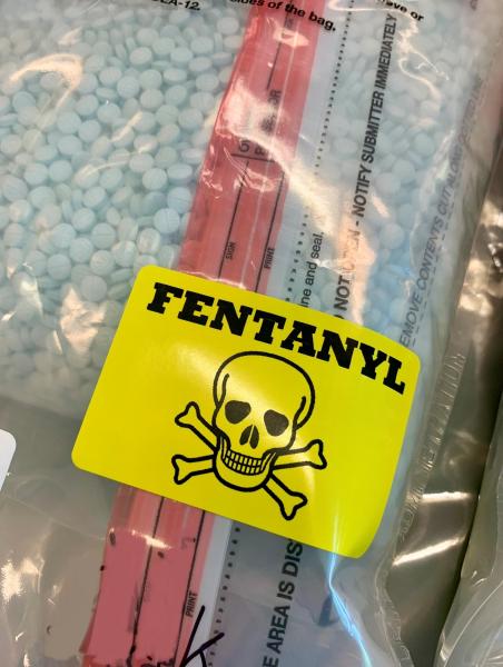bag of fentanyl pills with yellow sticker with skull and cross bones with the word fentanyl above it