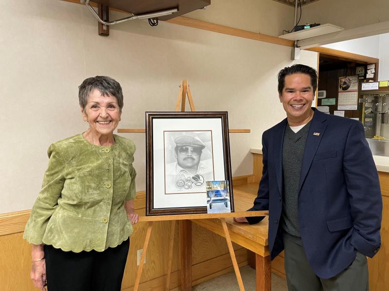 Joy and Jayson Seema with a portrait of Paul Seema.