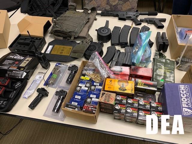 Table full of guns, ammunition and armor