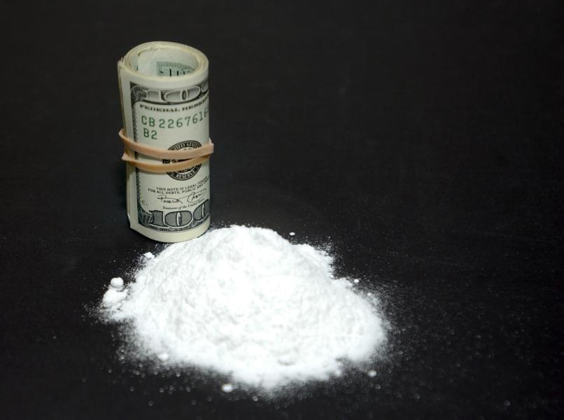 Powder cocaine next to a roll of cash.
