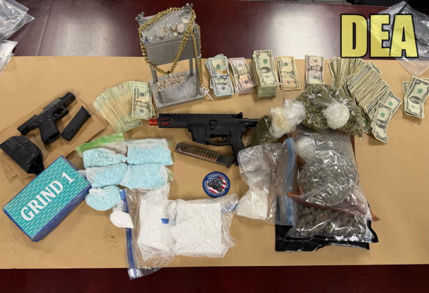 Guns, drugs, U.S. currency and other items seized by law enforcement during Operation Knoxville Thunder are displayed on a table.