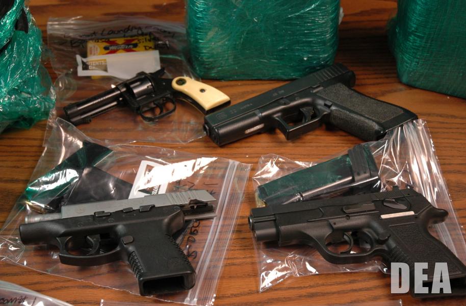 Guns, money and drugs seized in a DEA raid on drug traffickers.