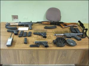 Automatic weapons, guns, ammunition, magazines, portable radio seized from the defendants. 