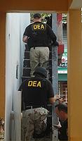 DEA special agents enter a residence in La Perla to execute an arrest warrant. 