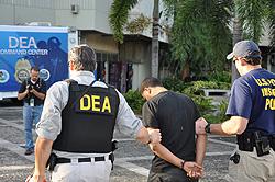 Agents escort a defendant for processing in San Juan, PR
