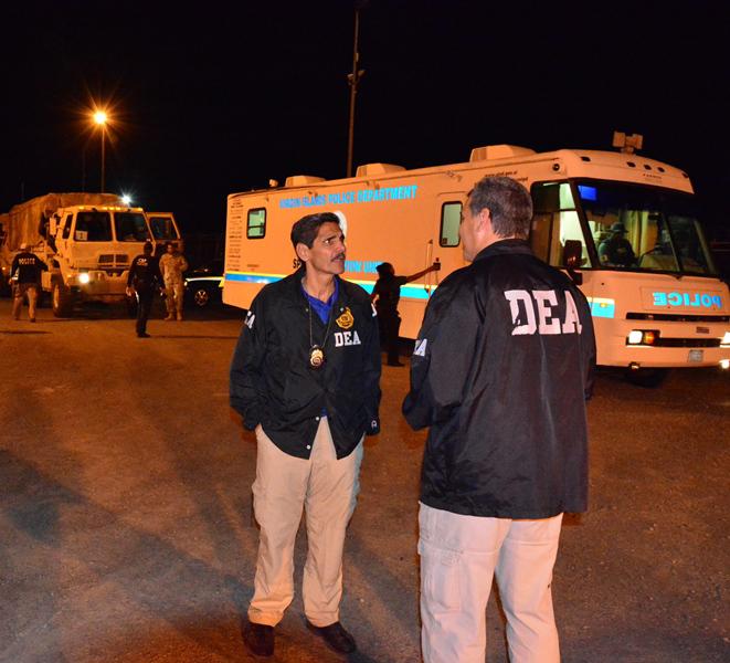 DEA Caribbean Division Special Agent in Charge Vito Salvatore Guarino (center), talking to one of his agents, leads the search warrant operation.