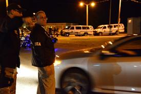 DEA agent directs PRPD-DEA Task Force Lieutenant Jorge Estrada to an arrest location.