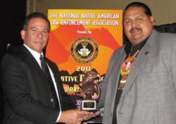 Resident Agent in Charge Reinaldo Lopez congratulating Captain James Shike III the recipient of the DEA Tribal Narcotics Officer of the Year Award.