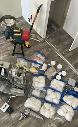 pill press, drugs, and other items found behind the hidden panels 