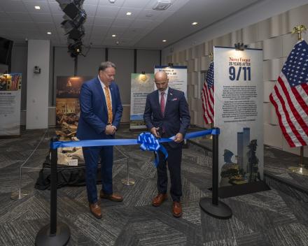 Administrator Cole and Deputy Administrator Salter cutting the blue ribbon to open the 9/11 Museum Exhibit